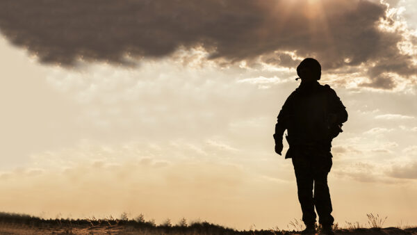 A silhouette of a solider in an open field