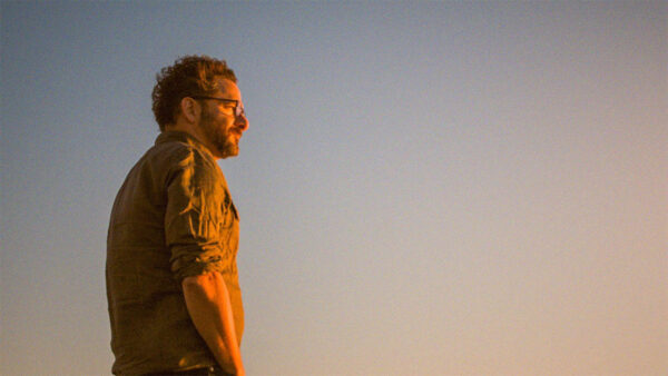 A man standing in front of a clear sky for episode two of A Brief History of the Future