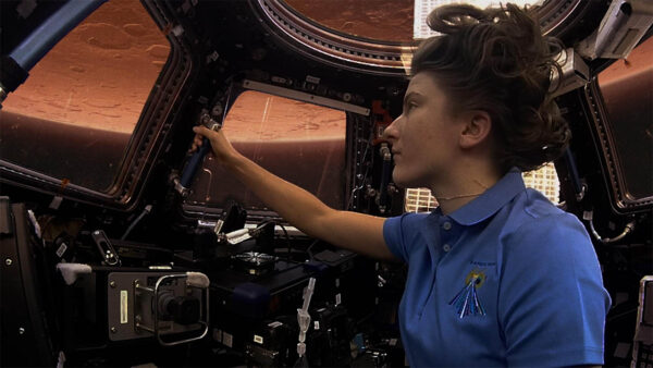 A woman working on a spacecraft in space