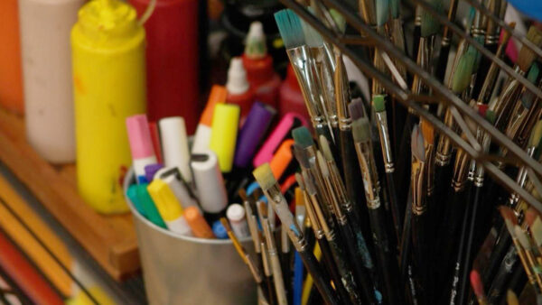 Art and paint supplies sit on a table, ready to be used