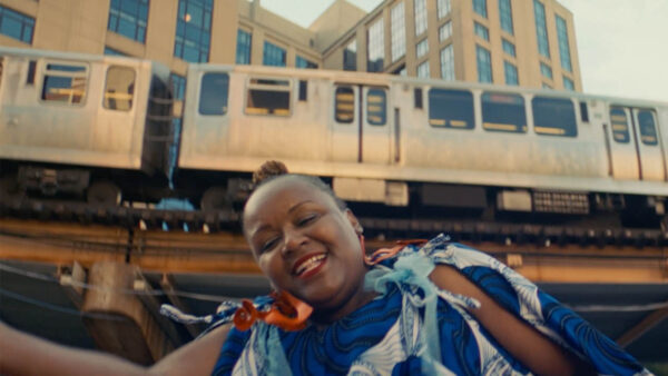 A woman dancing in front of a train