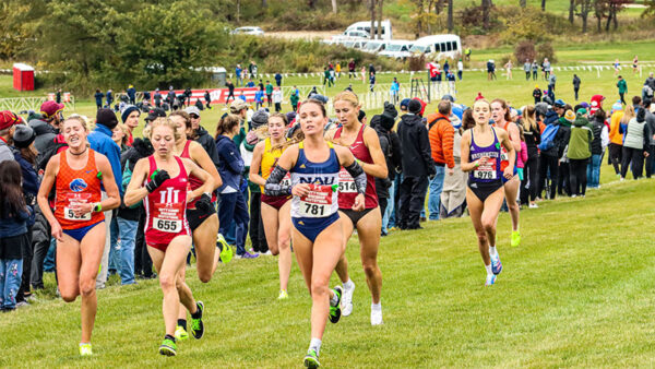 A group of women running in a cross country race, showcasing their determination and athleticism.