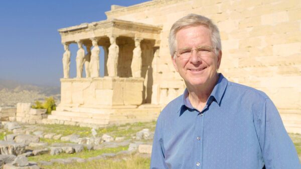 Rick Steves stands in front of Greek historical building