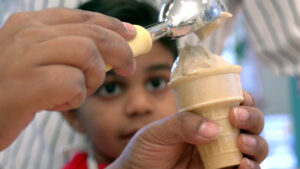 A kid looking at a banana swirl being scooped