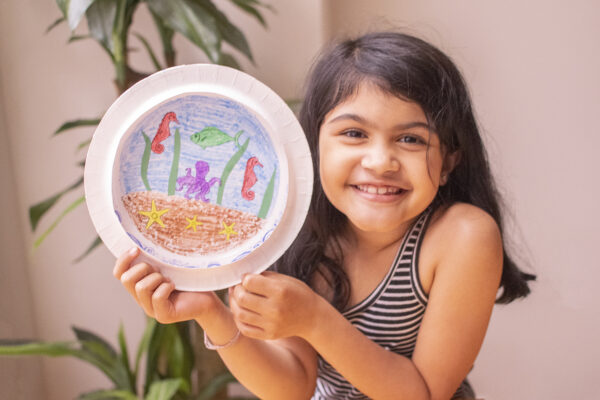 A girl with her paper plate aquarium