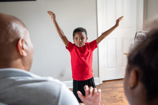 A boy performs his dance for his parents