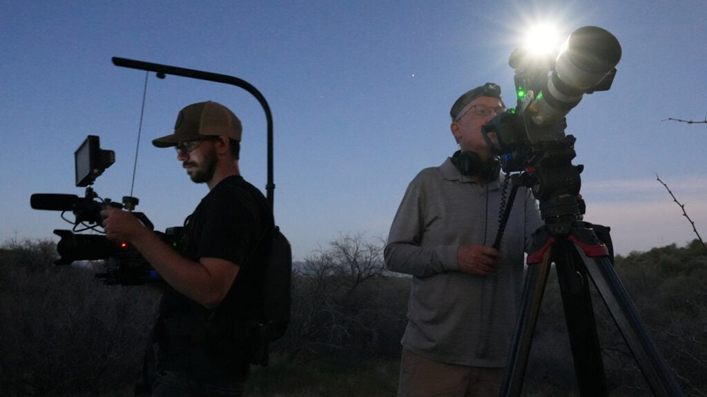 Two videographers film on location with two video cameras