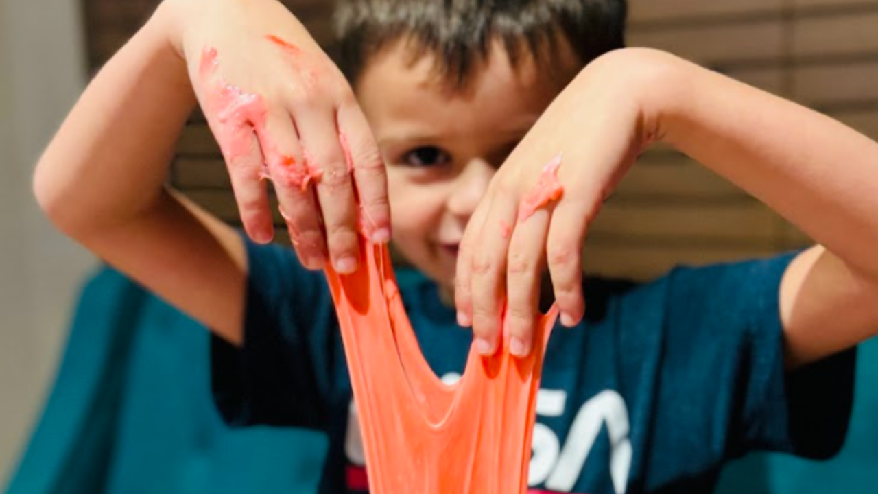 A kid holding up his red slime