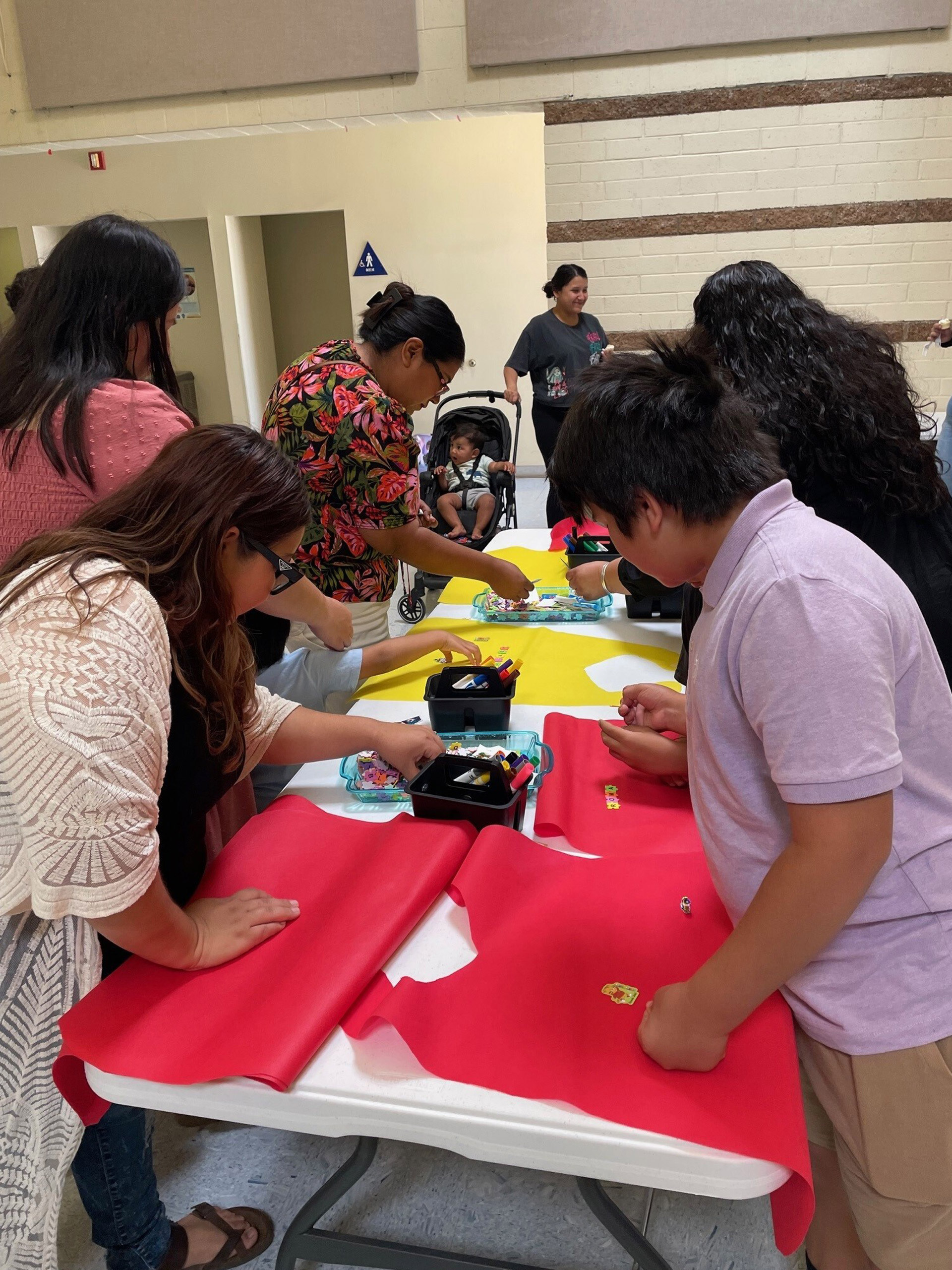 A diverse group of individuals collaborating on a project around a table, engaged in discussion and teamwork.