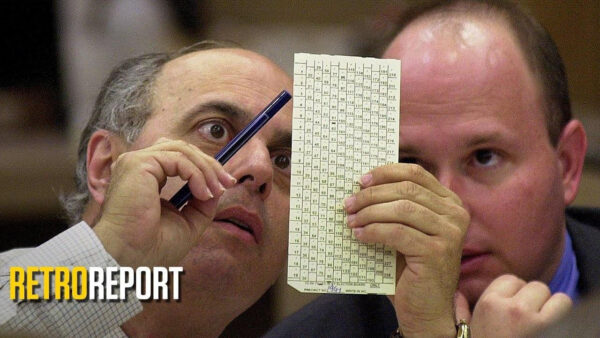 Two men examining a document together, with one man holding a pen, engaged in discussion or note-taking.