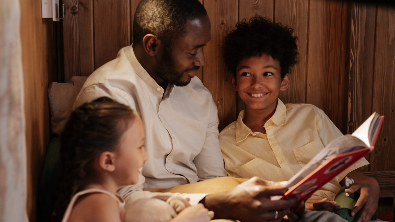 A dad reading a book to his kids