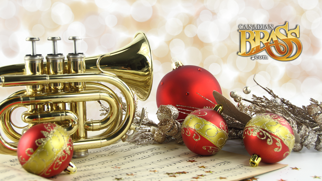 A photo of a trumpet resting on a table surrounded by Christmas ornaments