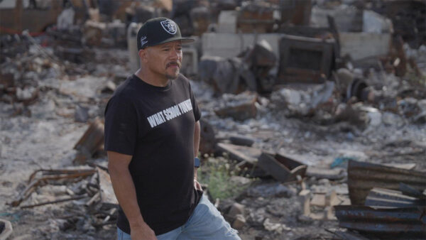 A man standing in rubble after a fire