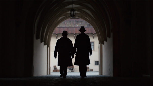 Two men walking in a tunnel