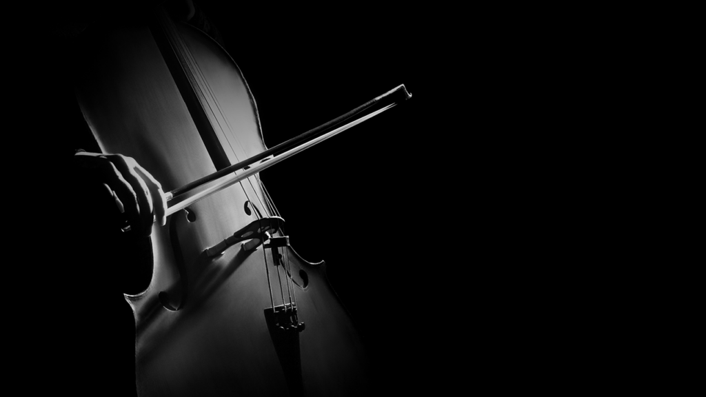 A moody, black and white photo of a cello being played