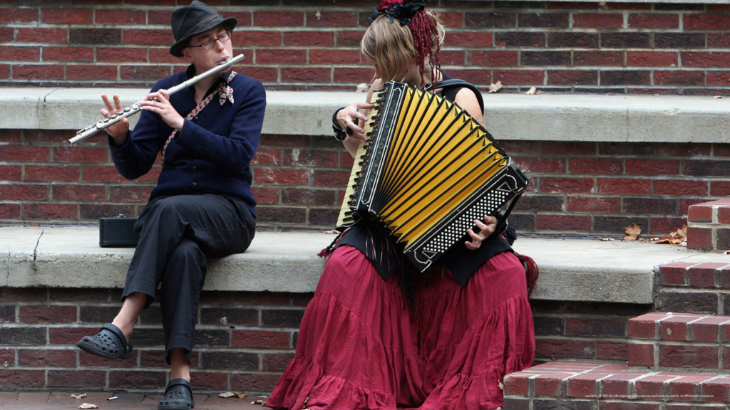 A flautist and accordion player play polka music at Pritchard Park in Asheville, NC