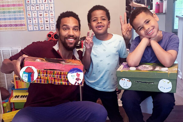 A dad and two kids hold up their boomboxes