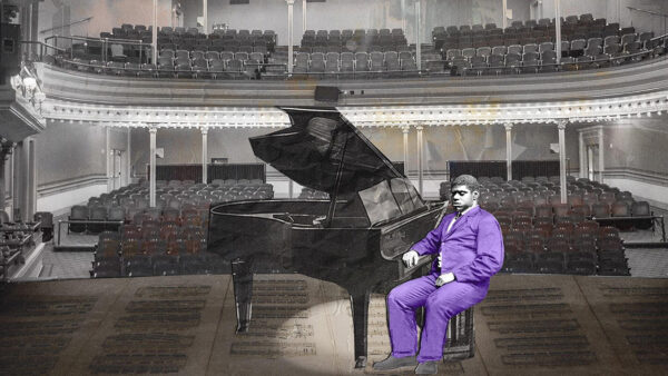 A man in a purple suit seated at a piano, poised to play, exuding elegance and creativity.