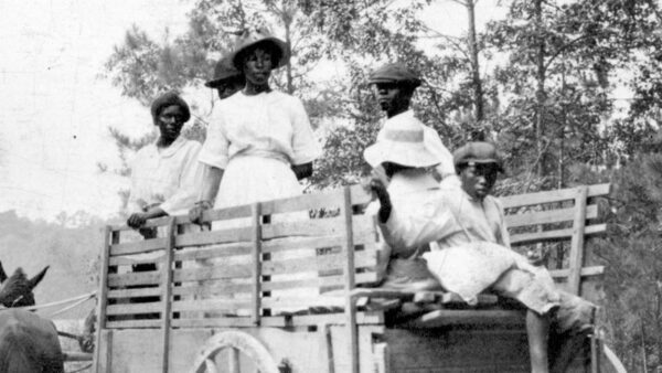 A black and white photo of people on a trailer