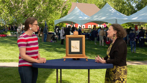 Two women speaking about an antique