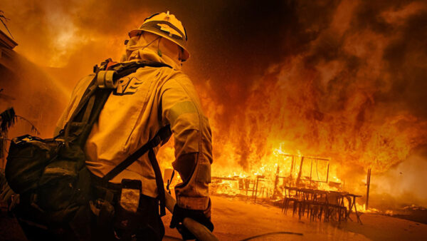 A firefighter in front of a fire