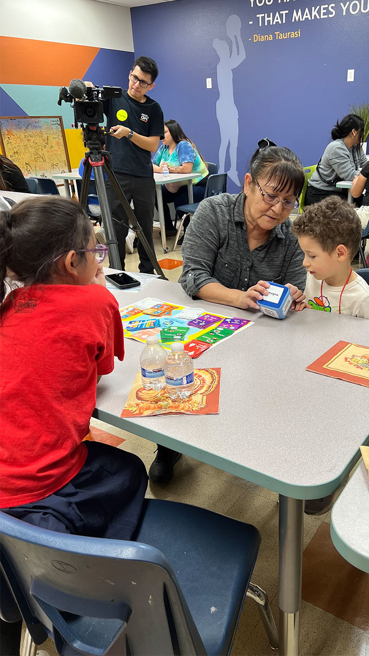 A group of children sitting around a table, engaged in conversation and sharing activities together.