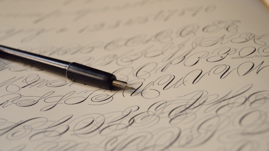 A calligraphy pen rests on top of a sheet of paper