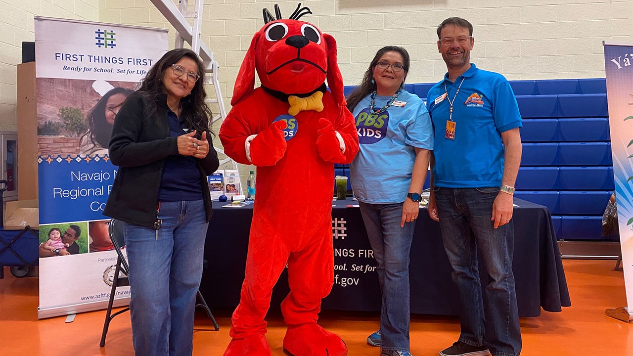 A group of people poses with a large mascot.