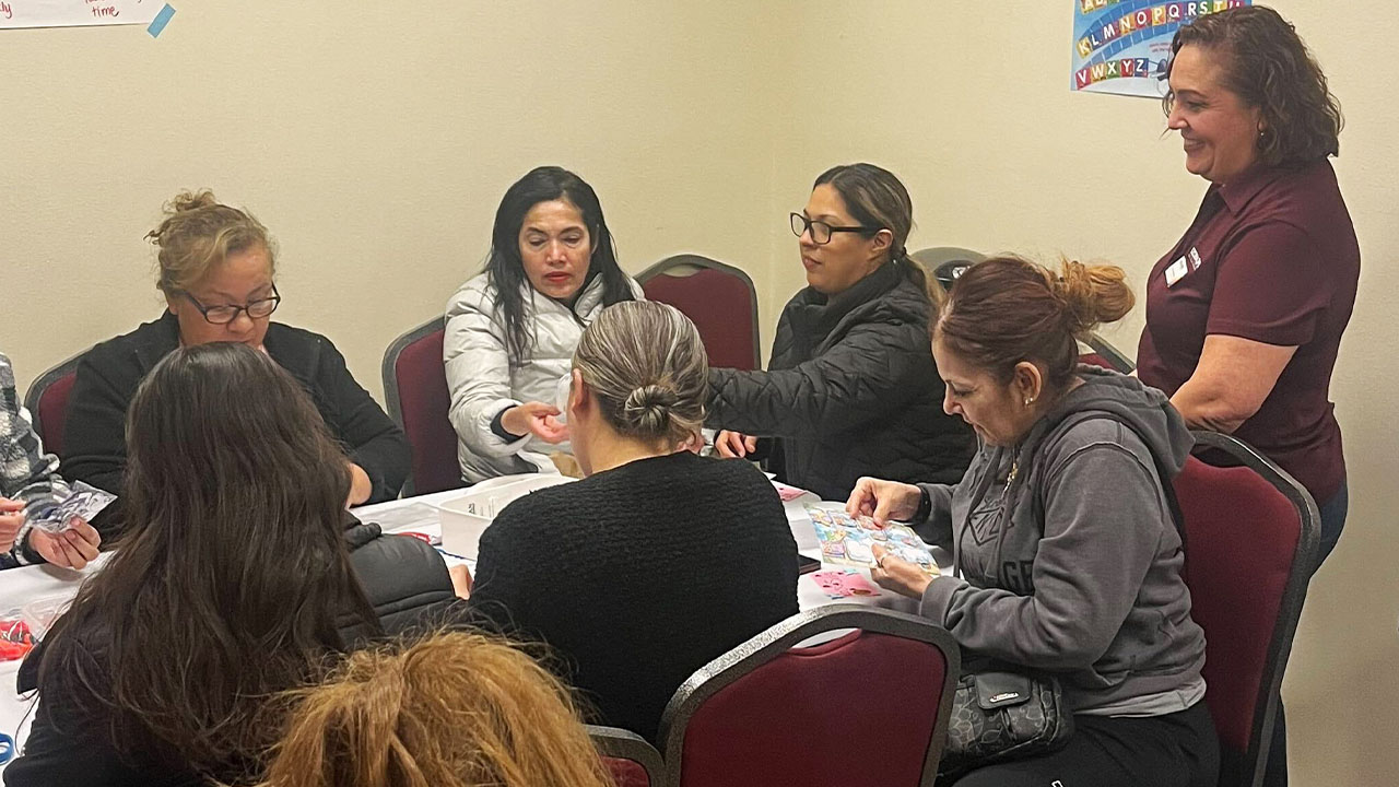 A group of women seated at a table, engaged in a discussion.