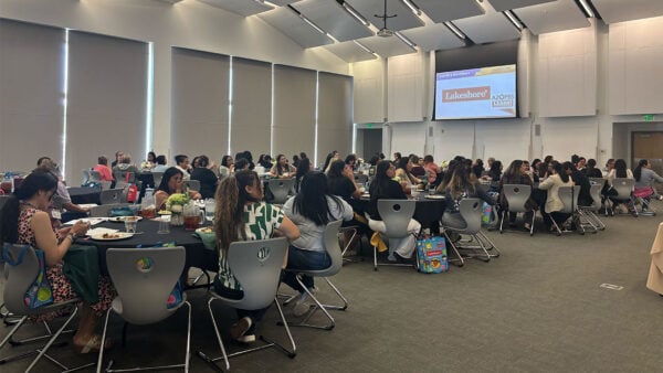 Several individuals gathered around tables in a large room.