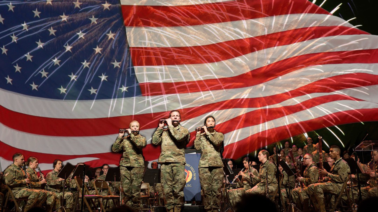 The US Army Field Band 3 performs on stage with an American flag in the background