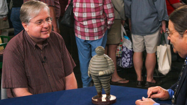 Two people looking at an old figurine