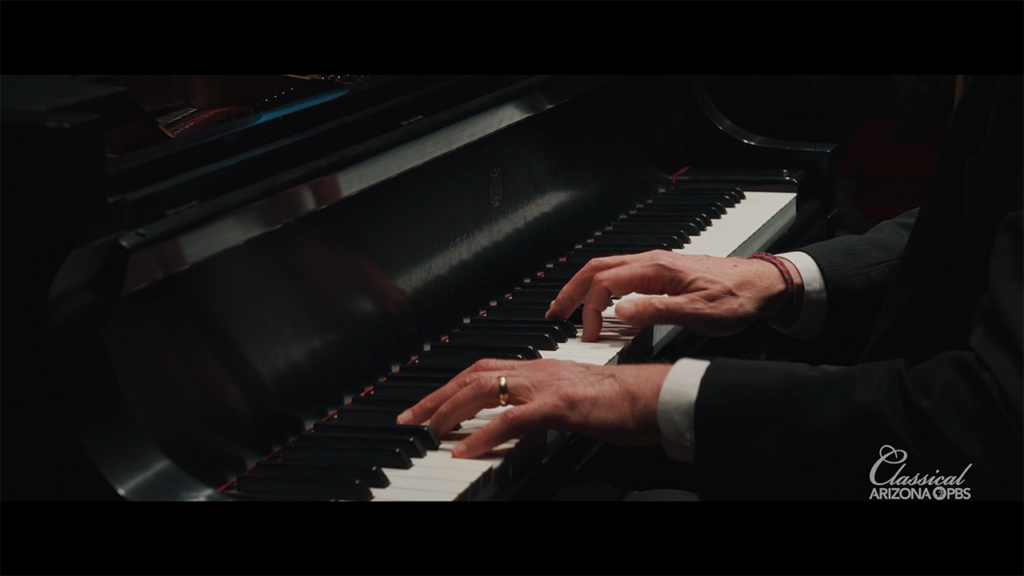 A man plays a grand piano