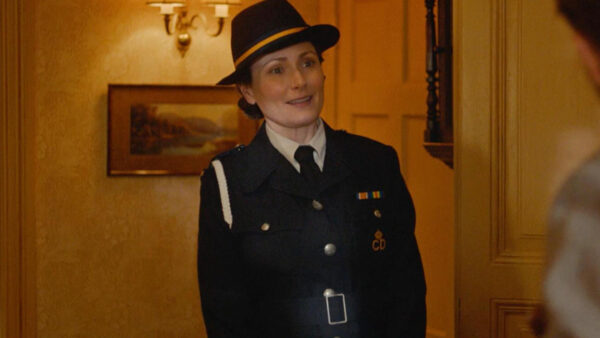 A woman in uniform stands confidently in a well-lit hallway, ready for her duties.