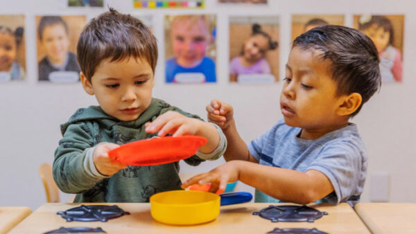 Two young boys learning to share their toys