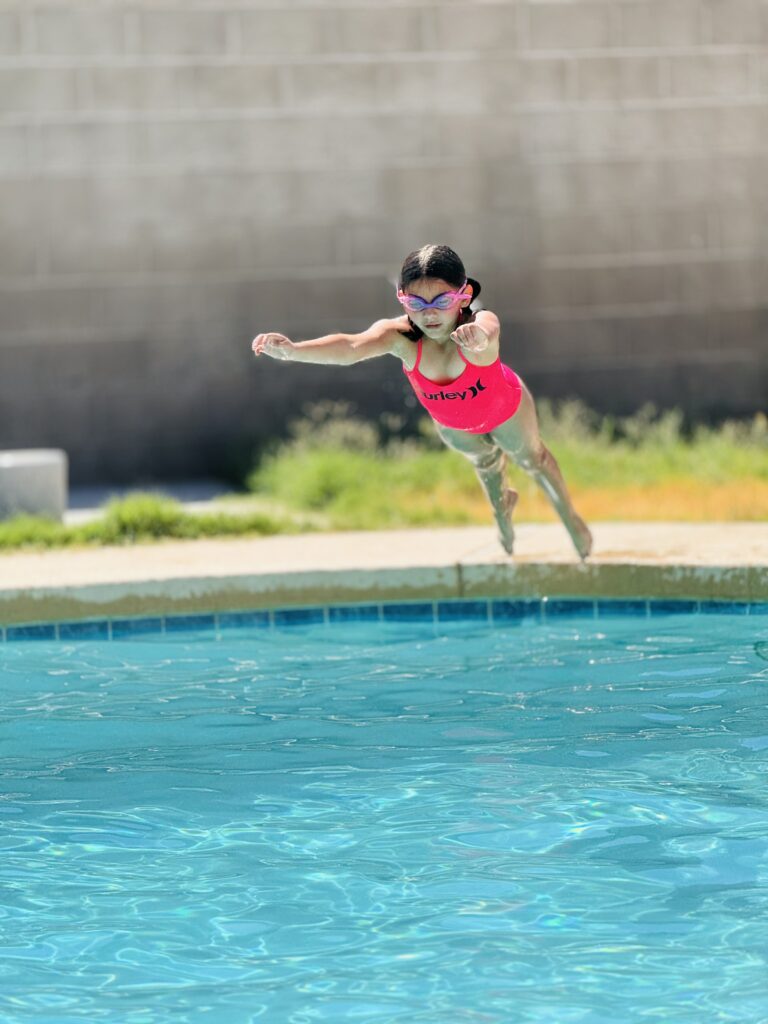 A girl jumping into the pool