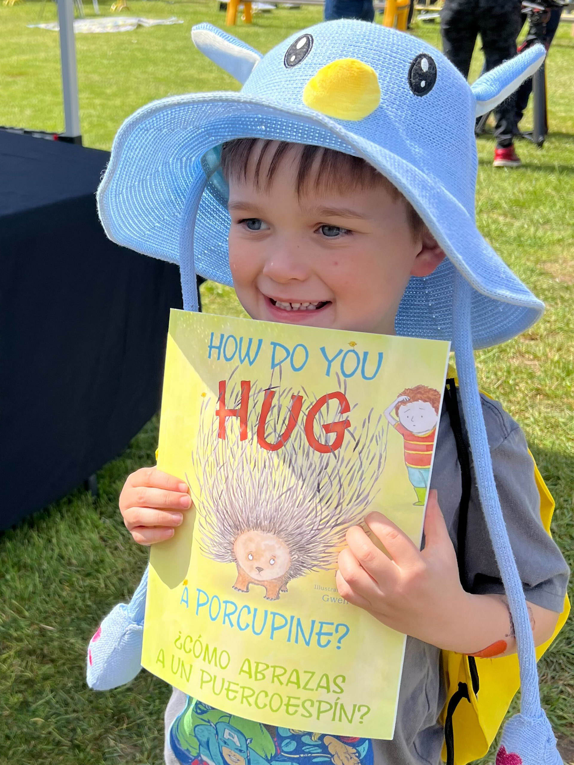 A young boy holds a book he received at Be My Neighbor Day
