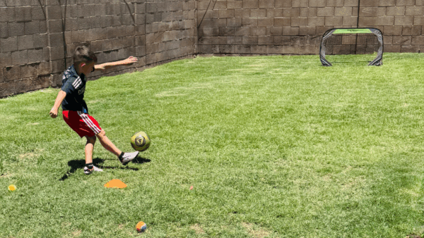 A kid playing soccer outside