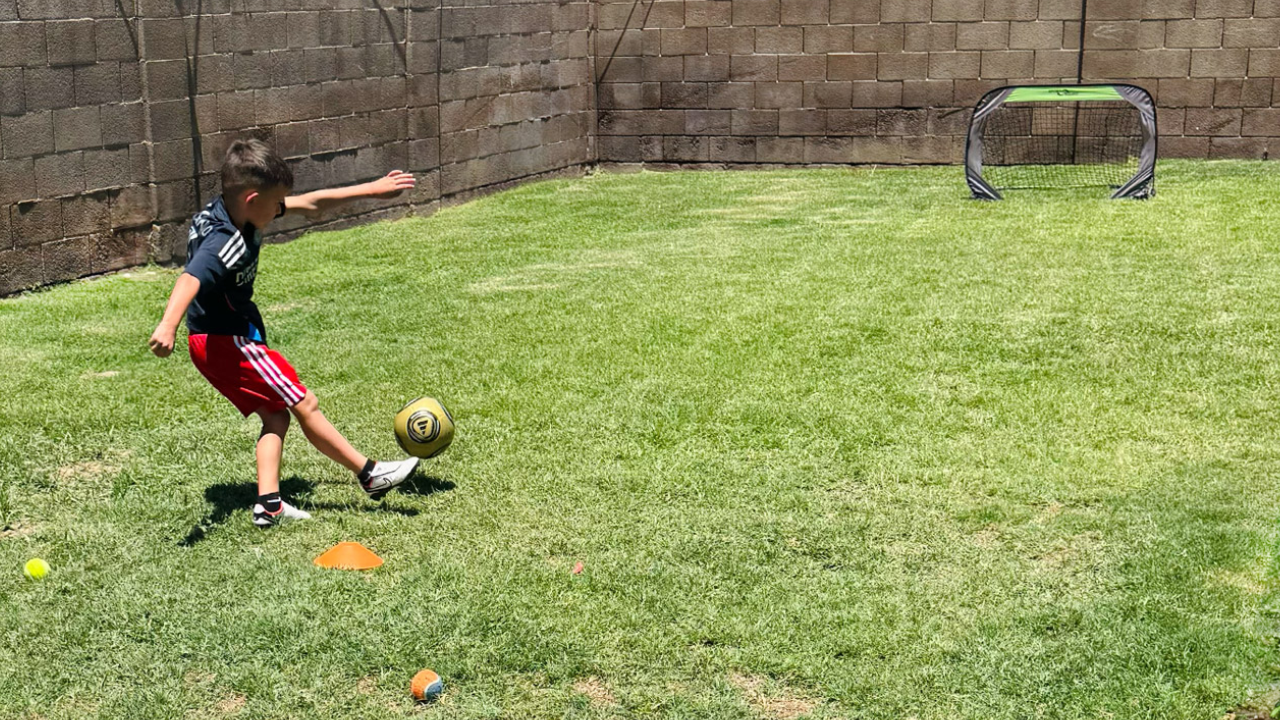 A kid playing soccer outside
