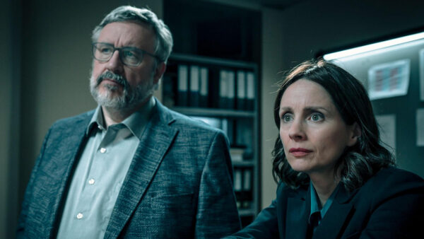 Two detectives looking off screen to something