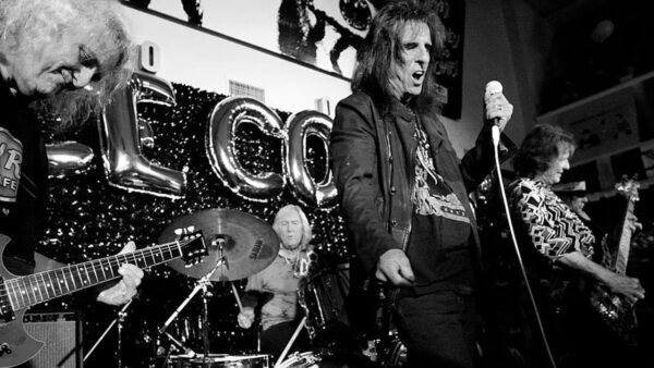 A black and white image of Alice Cooper performing