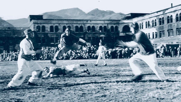 Football players playing on a field once used as a killing ground