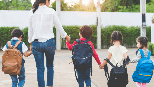 four kids and a parent walking to school
