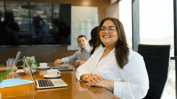 A lady smiling at the camera while in a meeting