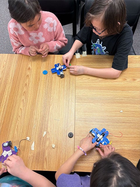 Four children collaborate on an activity