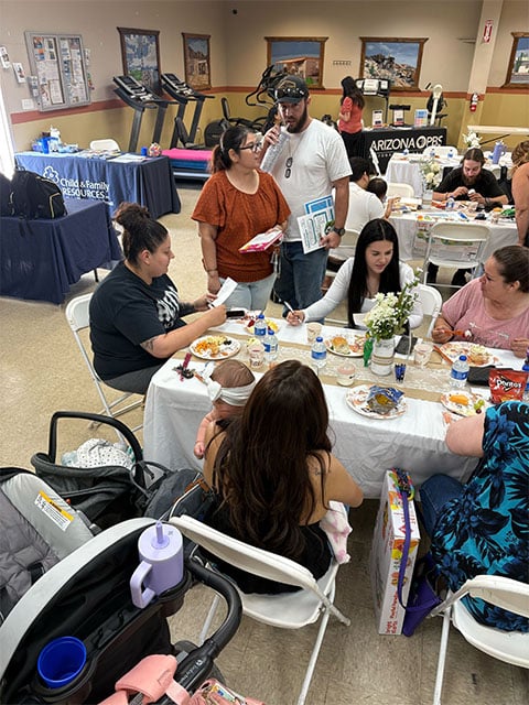 A diverse group of people seated at tables, engaged in conversation and enjoying their time together.
