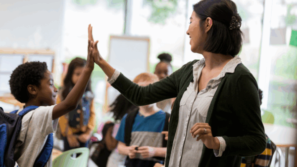 A teacher giving a student a high five