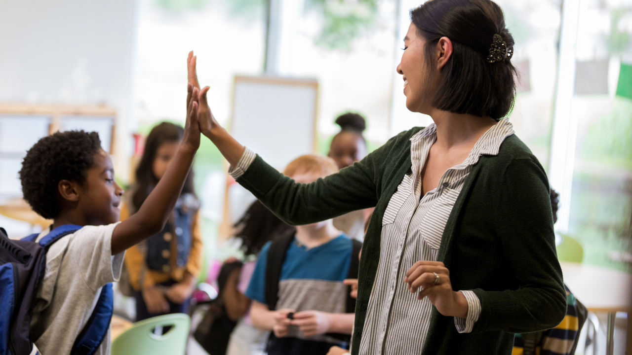A teacher giving a student a high five