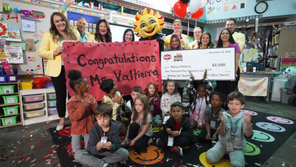 A teacher receives her check from Wishes For Teachers