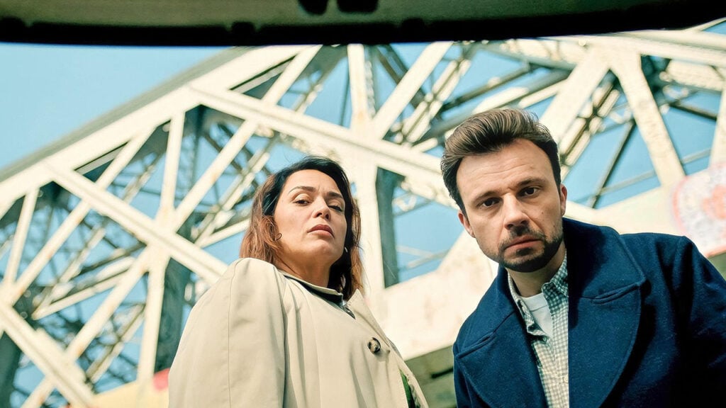 Mademoiselle Holmes looking down with another detective